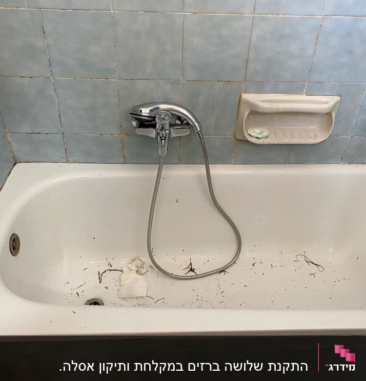 אמבטיה עם לכלוך, ברז ומקלחת יד